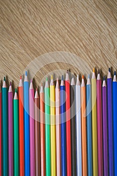 Color pencils on wooden background with copy space. Back to school and education concept.