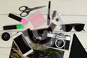 The color photo, the camera, markers, sticker, photoaccessories, shots of a film, flash card of memory and scissors on a table