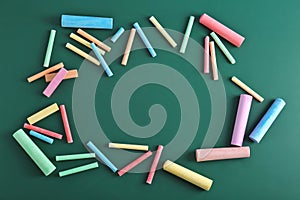 Color pieces of chalk on green background
