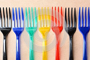 Color plastic forks on paper background