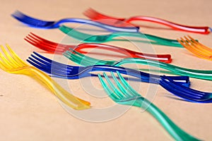 Color plastic forks on paper background