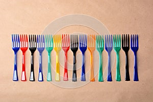 Color plastic forks on paper background