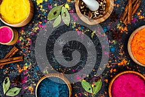 Color powder in wooden bowls, spices, herbs on dark background