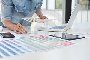 Color samples, colour chart, swatch sample, Graphic designer being selecting Color table and graphics tablet, pen at workplace wi