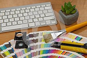 Color scale with stylus and magnifying glass on it and a notebook