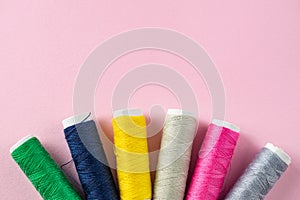 Color sewing threads on pink background