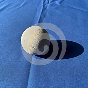 Color of the sphere and the vibrant blue fabric highlights the