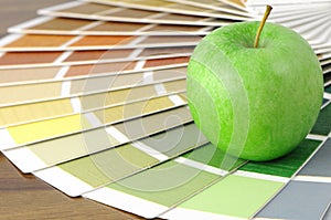 Color swatch on a table with green apple photo