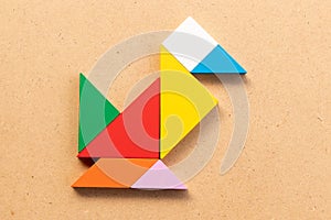 Color tangram in bird or duck shape on wood bacground