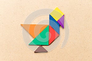 Color tangram in duck, swan or goose shape on wood background