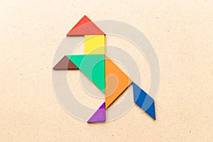 Color tangram in horse or mustang shape on wood background