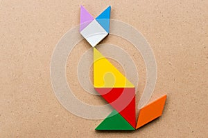 Color tangram puzzle in cat shape on wood background