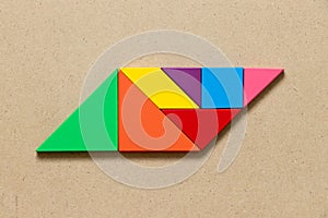 Color tangram in parallelogram shape on wood background photo