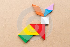 Color tangram in rabbit shape on wood background