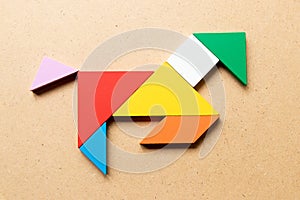 Color tangram in running horse shape on wood background