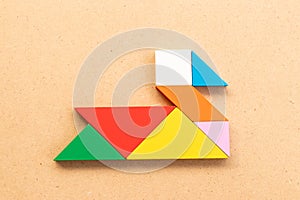 Color tangram in swan or duck shape on wood bacground