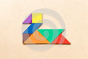 Color tangram in swan or duck shape on wood background