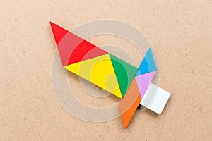 Color tangram in sword shape on wood background