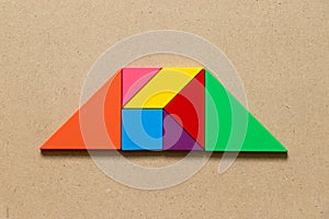 Color tangram in trapezoid shape on wood background