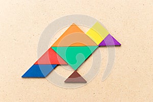 Color tangram in vulture bird shape on wood background