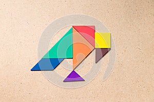 Color tangram in vulutre shape on wood background