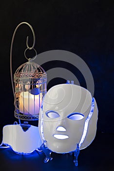 Color therapy mask glowing blue with candle
