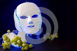 Color therapy mask glowing blue with grapes