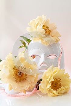 Color therapy mask glowing red on, peonies