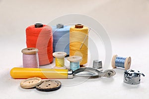 Color threads, tracing wheel and other sewing accessories on white table