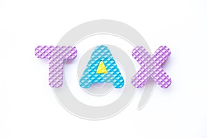 Color toy foam alphabet in word tax on white background