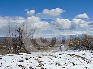 The Colorado River flows past snowy banks after a snowstorm