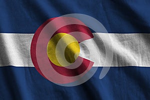 Colorado US state flag with big folds waving close up under the studio light indoors. The official symbols and colors in