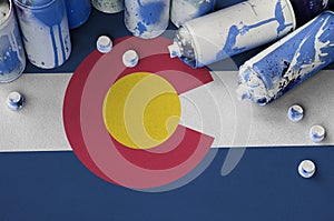 Colorado US state flag and few used aerosol spray cans for graffiti painting. Street art culture concept