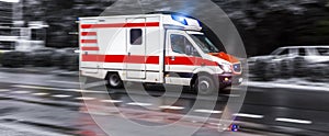 Colored ambulance car speeding in black and white