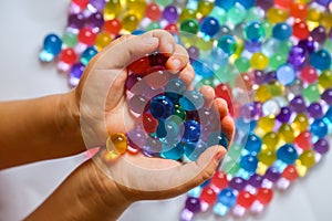 Colored balls of hydrogel in children`s palms