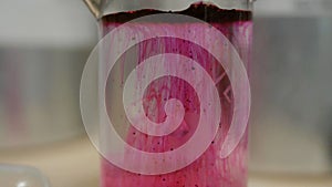 Colored beautiful chemical reaction in flask. Pink or red liquid dissolves in flask. Pink matter in the flask. Pink or