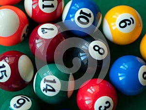 Colored billiard balls, close up. Striped and colorful balls on green table