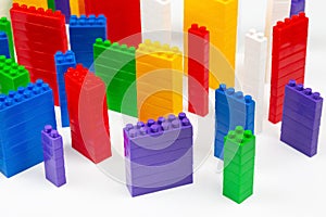 Colored blocks of a plastic constructor on a white background in the form of multi-storey buildings. concept of modern buildings