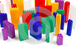 Colored blocks of a plastic constructor on a white background in the form of multi-storey buildings. concept of modern buildings