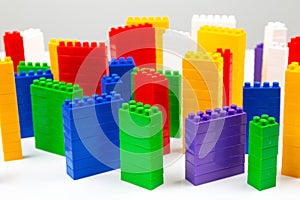 Colored blocks of a plastic constructor on a white background in the form of multi-storey buildings. concept of modern buildings