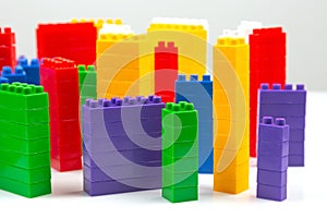 Colored blocks of a plastic constructor on a white background in the form of multi-storey buildings. concept of modern buildings