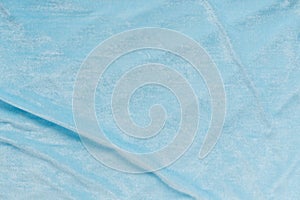 Colored blue textile satin fabric folded in folds and waves with highlights and texture