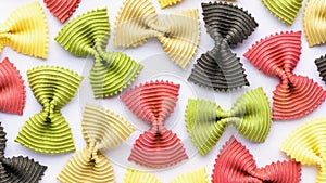 Colored bow tie pasta. Closeup multiple farfalle isolated on white background.