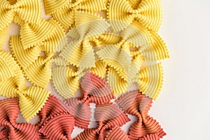 Colored bow tie pasta. Closeup multiple farfalle isolated on white background