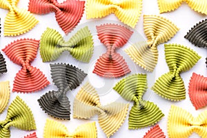 Colored bow tie pasta. Closeup multiple farfalle on white background