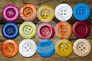 Colored buttons on wooden board, Colorful buttons, on old wooden