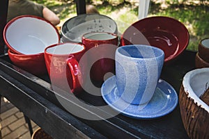 colored ceramic mugs on a wooden shelf