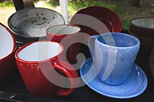 colored ceramic mugs on a wooden shelf