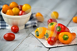 Colored cherry tomatoes and mini paprika on a wooden table