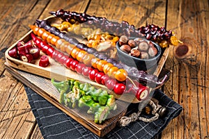 Colored Churchkhela Georgian sweets with Walnuts and hazelnuts. Wooden background. Top view